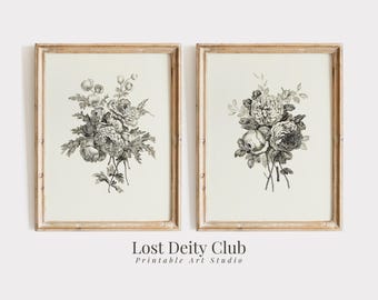 以下が含まれることがあります： 白壁に掛けられた、ヴィンテージスタイルの、花束のモノクロの植物画が2枚。シンプルな木製の額縁に入っています。