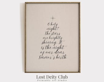 Puede incluir: Impresión enmarcada con un marco dorado. La obra de arte presenta el texto "O holy night! The stars are brightly shining. It is the night of our dear Savior's birth" en forma de árbol de Navidad. Las palabras "Lost Deity Club Printable Art Studio" están en la parte inferior.