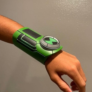 May include: A green and black wristwatch with a circular face and a symbol of an X inside a circle. The watch is worn on a person's wrist.