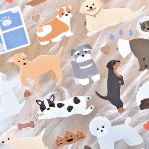 May include: A sheet of stickers featuring various dog breeds in different poses, including a corgi, a schnauzer, a dachshund, and a pug. The stickers are on a white fluffy background.