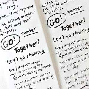 以下が含まれることがあります： 黒インクで手書きされたテキストが書かれた2枚の白い紙。テキストには「GO！Together！Let's go shopping」などのフレーズやその他の詩的な行が含まれています。シートはカジュアルで芸術的な美学を持っています。