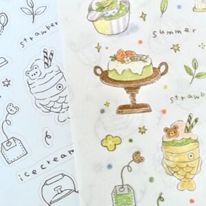 May include: A sheet of stickers featuring hand-drawn illustrations of desserts and tea. The stickers include cakes, ice cream, and tea bags, with the word "strawberry" written on the sheet. The color palette is soft, with pastel shades and black outlines.
