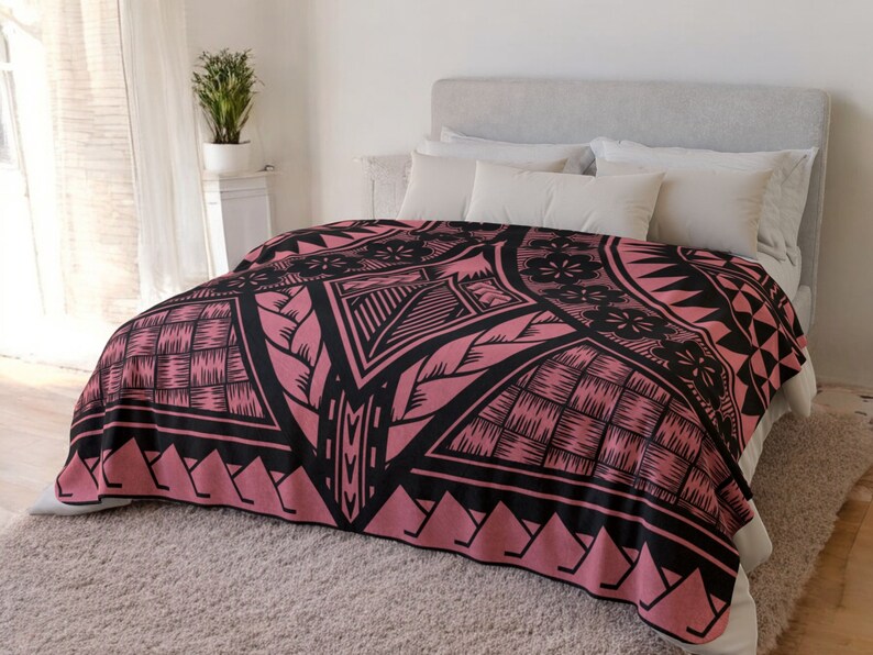 Puede incluir: Una manta de tiro de color rosa y negro con un dise&ntilde;o geom&eacute;trico. La manta est&aacute; hecha de tela suave y mullida y presenta un motivo tradicional polinesio.