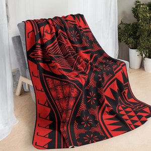 Puede incluir: Manta de tiro roja y negra con un patr&oacute;n de inspiraci&oacute;n polinesia. El patr&oacute;n presenta formas geom&eacute;tricas, flores y una figura humana estilizada.