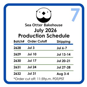 May include: A white rectangular sign with a blue border featuring a black sea otter icon and the text Sea Otter Bakehouse July 2026 Production Schedule. A table lists batch numbers 2628 through 2632 with corresponding order cutoffs and shipping dates.