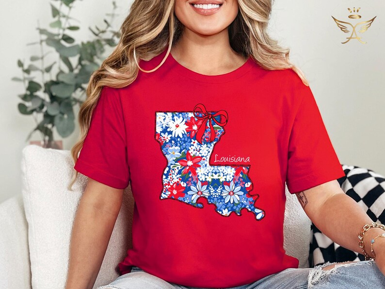 May include: Red t-shirt with a floral print of the state of Louisiana and the word "Louisiana" printed on the shirt.