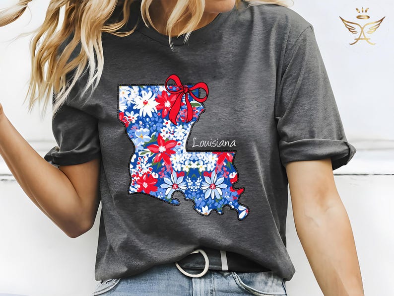 May include: A gray t-shirt with a floral print of the state of Louisiana. The print includes a red bow and the word "Louisiana".