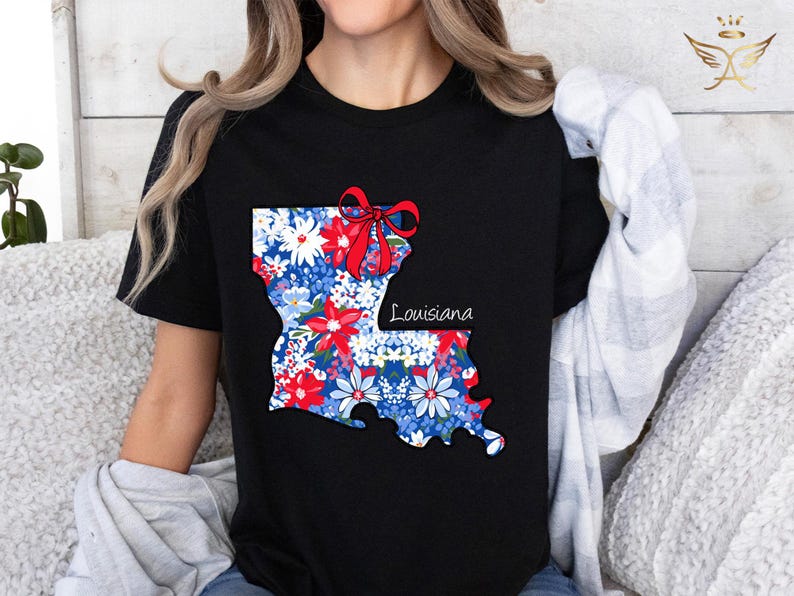 May include: Black t-shirt with a floral print of the state of Louisiana. The print includes a red bow and the word "Louisiana".