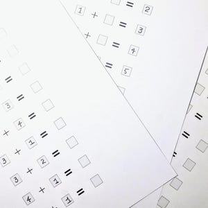 May include: A white sheet of paper with a series of addition problems written in black ink. The problems are all simple addition problems with the answers left blank.