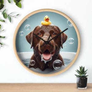 May include: A brown Labrador Retriever dog with a yellow rubber duck on its head is in a bathtub full of bubbles. The dog is smiling and looking at the camera. The image is a clock face with the dog's head in the center.