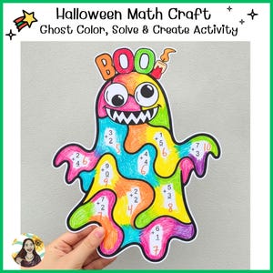 May include: A Halloween math craft activity featuring a ghost shape colored in bright rainbow sections. The ghost has large googly eyes, a wide toothy grin, and the word BOO at the top. It includes addition problems with answers written in orange.