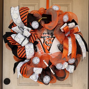 May include: A decorative volleyball-themed wreath with orange, black, and white ribbons and mesh. The wreath features volleyball accents and a central design with a tiger mascot and the text "Class of 2024".