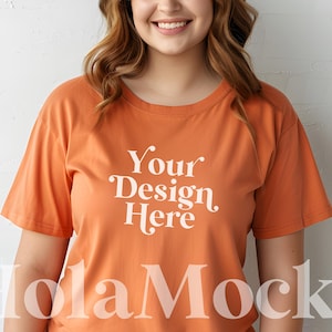 May include: A woman wearing a burnt orange t-shirt with the text "Your Design Here" printed in white.