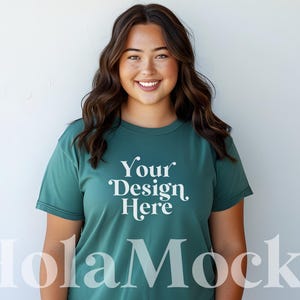 May include: A woman wearing a teal green t-shirt with the text "Your Design Here" printed on the front.