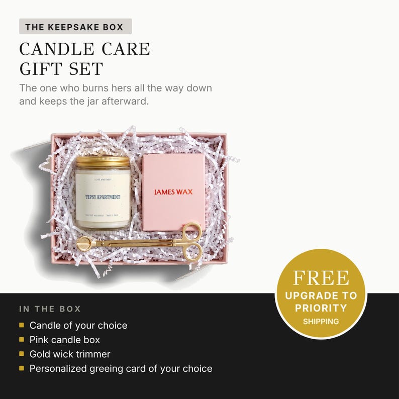a gift set called "The Keepsake Box Candle Care Gift Set" presented in a pink box with white paper lining. The gift set includes a candle, a wick trimmer, a gold candle box, and a personalized greeting card.