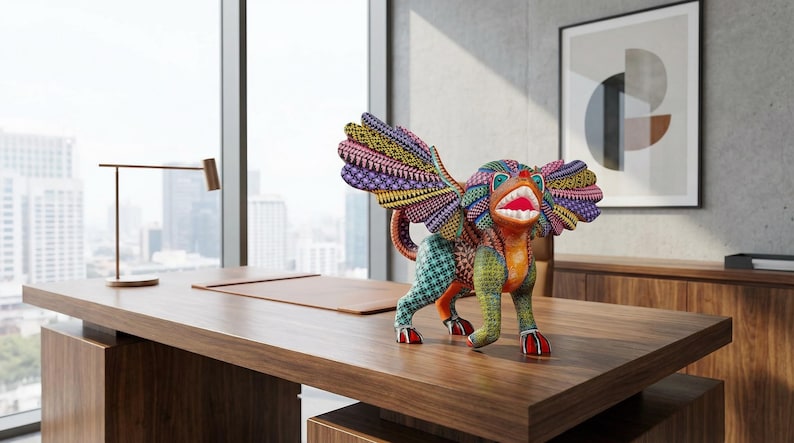 May include: A multi-coloured alebrije sculpture featuring a mythical creature with large wings, a wide open mouth with visible teeth, and intricate geometric patterns in shades of orange, green, purple, yellow, and blue covering its entire body.