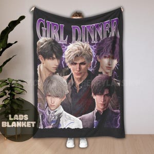 Può includere: Coperta nera con una grafica di cinque figure maschili in stile anime con vari colori di capelli. La coperta presenta il testo "GIRL DINNER" in viola e "LADS BLANKET" in bianco.
