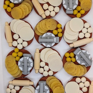 May include: Overhead shot of nine circular arrangements, each on a brown plate. Each arrangement includes a rolling pin, a gray and white patterned press, dough, and yellow spheres. Some arrangements have stacks of tortillas.