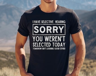 Może przedstawiać: Czarny T-shirt z białym tekstem, który brzmi: "Mam selektywny słuch. Przepraszam, nie zostałeś wybrany dzisiaj. Jutro też nie wygląda dobrze."
