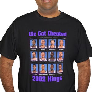 Può includere: Maglietta nera con una grafica viola della squadra di basket dei Sacramento Kings del 2002. La grafica dice "We Got Cheated" e include i nomi dei giocatori.
