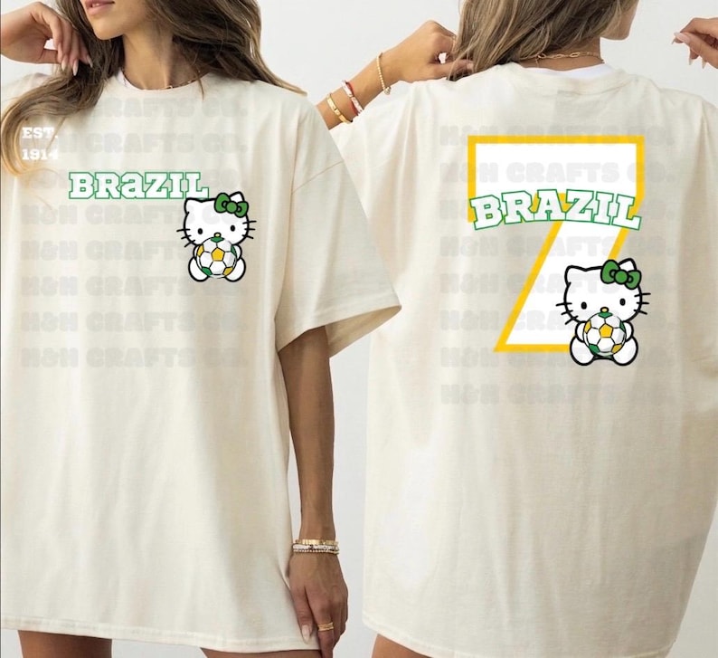 K&ouml;nnte beinhalten: Cremefarbenes T-Shirt mit dem Wort "BRAZIL" in Gr&uuml;n und einer Zeichentrickfigur, die einen Fu&szlig;ball h&auml;lt. Auf der R&uuml;ckseite des Shirts befindet sich ein gro&szlig;es gelb-gr&uuml;nes Design mit dem Wort "BRAZIL" und derselben Figur.