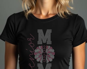 May include: Black t-shirt featuring the word "Senior" in pink script. The word "MOM" is spelled out in silver rhinestones, with a pom-pom design in the centre and the year "2025".