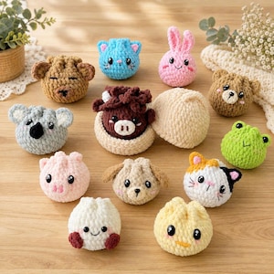 Puede incluir: Una colección de pequeños juguetes de peluche tejidos a ganchillo con forma redonda que representan varios rostros de animales, como un koala, un oso, una rana, un gato y un conejo. Las figuras de hilo suave tienen detalles bordados y ojos.