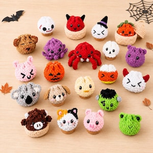 Puede incluir: Una colección de pequeñas figuras de peluche tejidas a ganchillo que representan varios personajes, incluyendo una araña roja, un monstruo verde, un gato calicó, un cerdo, una rana, un koala, un cachorro, una calavera, una calabaza y un caramelo.