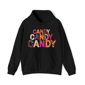 Op de afbeelding: Zwarte hoodie met een kleurrijke snoepprint die drie keer "CANDY" zegt.