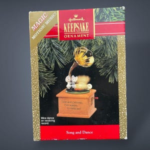 Könnte beinhalten: Hallmark Keepsake Ornament in einer Box. Das Ornament zeigt ein Miniatur-Grammophon mit zwei Mäusen, die auf einer Schallplatte tanzen. Auf der Box steht "Song and Dance" und "Love and Christmas... Two reasons to celebrate!"