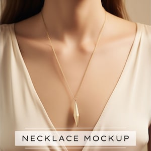 May include: A gold-colored necklace with a geometric pendant. The pendant is a long, faceted shape. The necklace is displayed on a person wearing a cream-colored top. The text "NECKLACE MOCKUP" is at the bottom of the image.