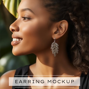 May include: A woman wearing a black top with silver leaf-shaped earrings. The earrings are dangling and have a delicate design.  EARRING MOCKUP.