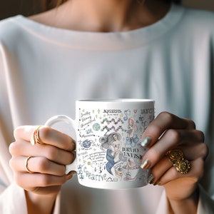 May include: White ceramic mug with a colorful illustration of an Aquarius zodiac sign. The illustration includes a mermaid, stars, and the text "Born to Envision".