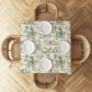a dining table set with four white plates and cutlery, surrounded by four wicker chairs on a wooden floor.