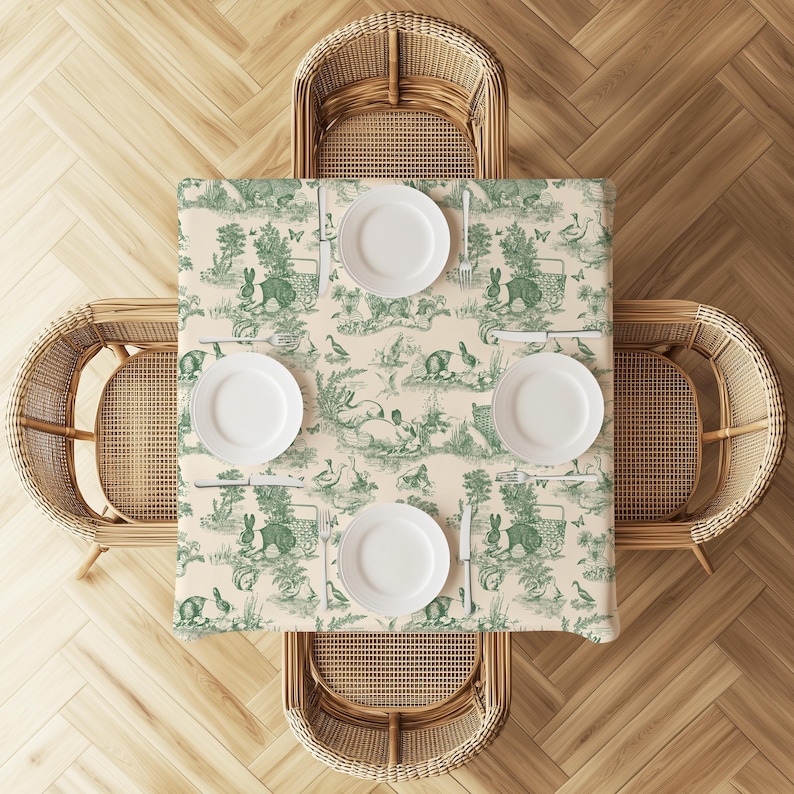 a dining table set with four white plates and cutlery, surrounded by four wicker chairs on a wooden floor.
