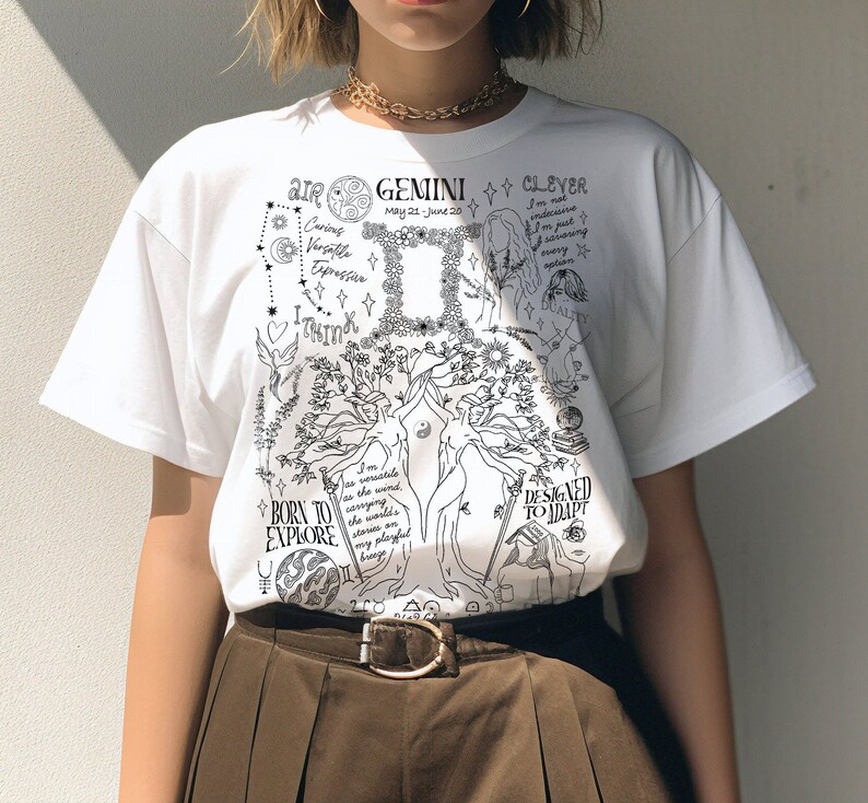 Op de afbeelding: Wit T-shirt met een zwart-witte grafische print met het sterrenbeeld Tweelingen, een boom en de tekst "AIR GEMINI CLEVER May 21-June 20 BORN TO EXPLORE DESIGNED TO ADAPT I'm as versatile as the wind carrying the world's stars on my playful breeze."