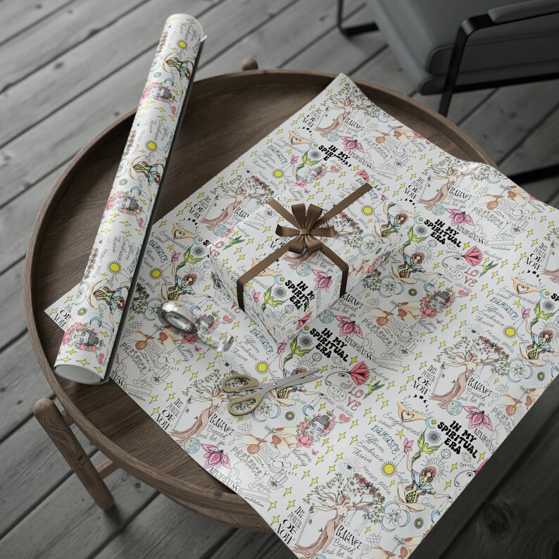 May include: White wrapping paper with a repeating pattern of a tree with the words "In My Spiritual Era" and other inspirational phrases. The paper is decorated with flowers, stars, and other whimsical illustrations.