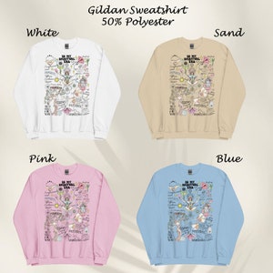Puede incluir: Cuatro sudaderas Gildan en diferentes colores: blanco, arena, rosa y azul. Cada sudadera presenta un dise&ntilde;o gr&aacute;fico con el texto "In My Spiritual Era" y varias otras palabras y s&iacute;mbolos.