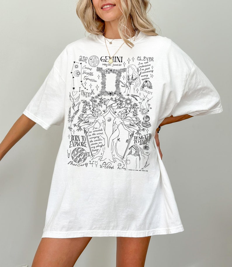 Op de afbeelding: Wit overhemd met een zwarte grafische print van een boom met astrologische symbolen en de tekst "AIR GEMINI CLEVER May 21-June 20 Caring Versatile Expressive I THINK BORN TO EXPLORE I'm the variable energy saving the world's stories on every planet Mercury 240 120-264 DESIGNED TO ADAPT".