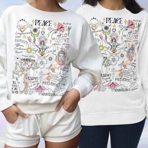 May include: White sweatshirt with a colorful graphic print featuring the word "PEACE" and various symbols related to mindfulness, yoga, and self-care. The graphic includes phrases like "inner peace", "balance", "breathe", "presence", and "mindfulness".