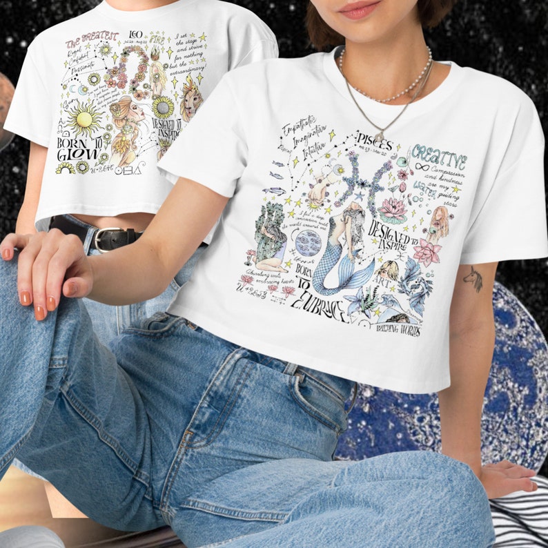 Peut inclure: T-shirt blanc court avec un motif graphique color&eacute; repr&eacute;sentant une sir&egrave;ne, des &eacute;toiles et le texte "Pisces", "Creative", "Designed to Aspire", "Born to Embrace", et "Breathing Worlds".