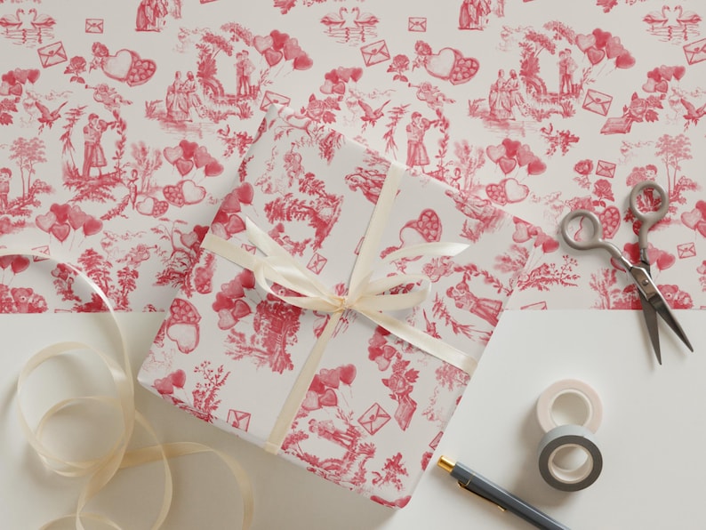 Pu&ograve; includere: Una scatola regalo bianca avvolta in carta a motivi rossi e bianchi con un nastro bianco. La carta presenta un motivo ripetitivo di cuori, fiori e coppie in un'ambientazione romantica. La scatola &egrave; appoggiata su una superficie bianca con forbici, nastro adesivo e una penna.