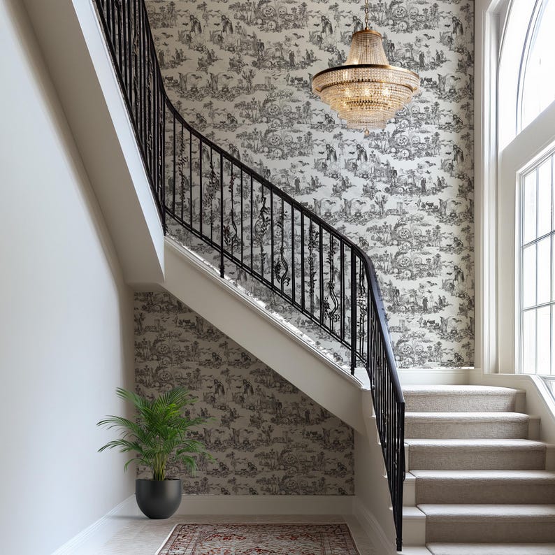 May include: A grand staircase with a black wrought iron railing and a patterned wallpaper featuring a black and white pastoral scene. A large crystal chandelier hangs above the stairs, and a potted plant sits at the base.