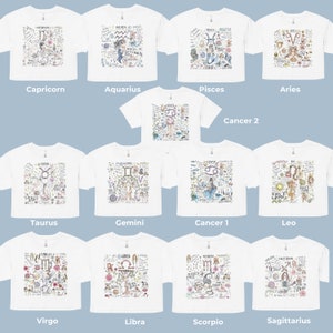 Peut inclure: Douze t-shirts blancs avec des signes du zodiaque et des illustrations color&eacute;s. Chaque t-shirt pr&eacute;sente un signe du zodiaque diff&eacute;rent, notamment Capricorne, Verseau, Poissons, B&eacute;lier, Taureau, G&eacute;meaux, Cancer, Lion, Vierge, Balance, Scorpion et Sagittaire.
