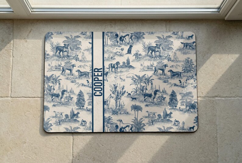 A decorative dog food mat with a repeating pattern of various animals and landscapes, including palm trees, birds, and other wildlife. The name "COOPER" is written in the center of the mouse pad.