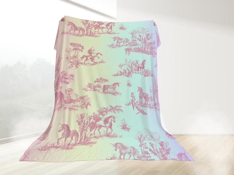 May include: A large, draped fabric with a pastel gradient background of yellow, green, and blue. The fabric features a repeating pink toile pattern of unicorns, riders, and landscapes. The overall theme is fantasy and whimsy.