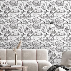 May include: Black and white Halloween-themed wallpaper featuring a repeating toile pattern. The design includes pumpkins, bats, skeletons, and other spooky elements. The wallpaper is displayed on a wall behind a beige sofa and a wooden table.