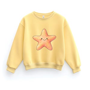 May include: A light yellow sweatshirt featuring a smiling starfish graphic. The starfish is a warm coral color with a textured appearance. The sweatshirt has a crew neck and long sleeves, perfect for casual wear.