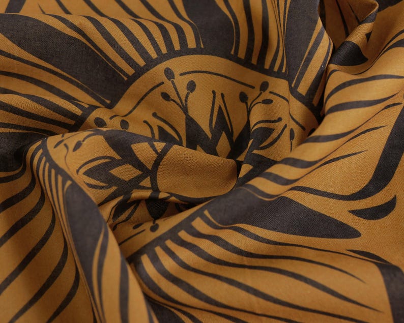 May include: A brown fabric with a black geometric pattern. The pattern features a repeating design of lines and circles.