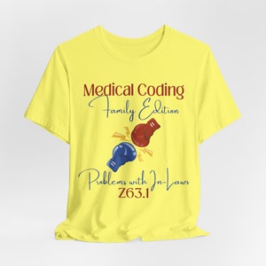 Könnte beinhalten: Gelbes T-Shirt mit dem Text "Medical Coding Family Edition" in kastanienbrauner und marineblauer Schrift. Das Shirt zeigt eine Grafik von roten und blauen Boxhandschuhen mit Blitzen und dem Text "Problems with In-Laws Z63.1".